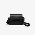 A black grained leather handbag with light gold metalware and an adjustable strap for a comfortable crossbody or shoulder fit. 